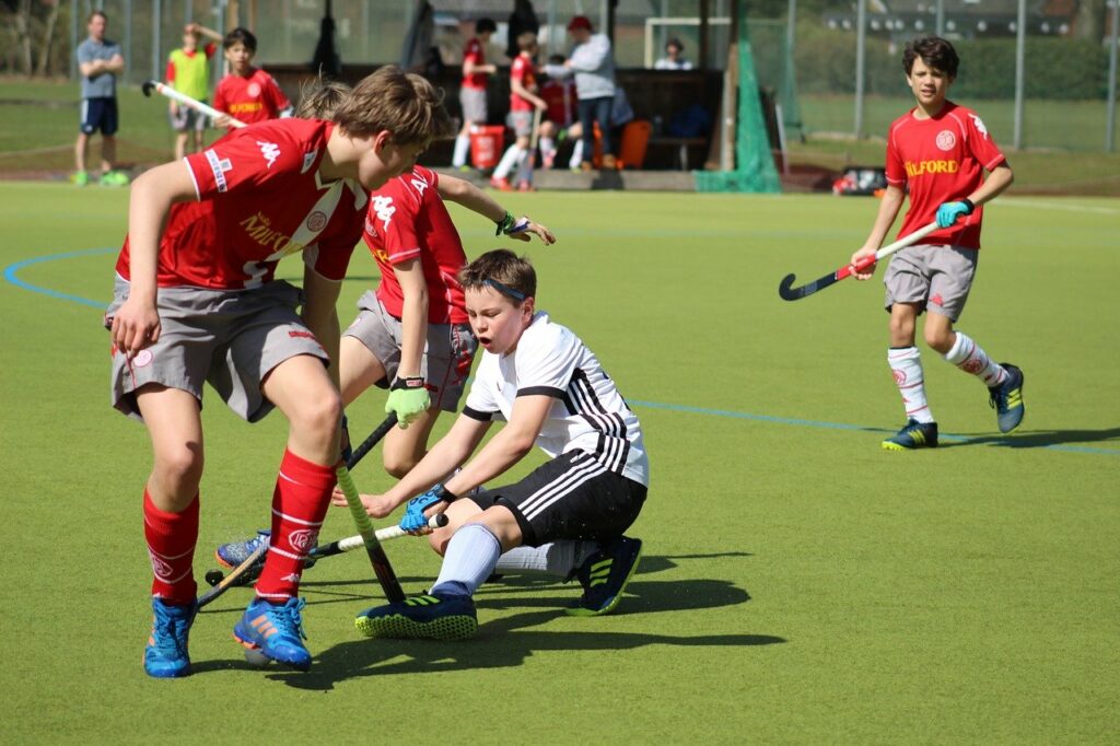 Boys playing hockey on artificial grass surface