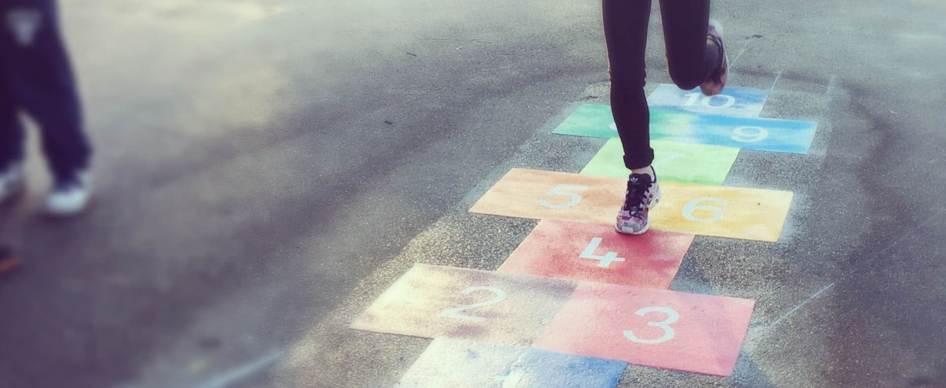 schoolchild running across hopscotch playground markings