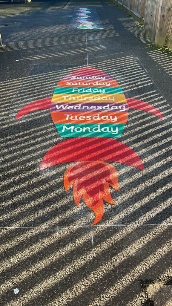 custom rocket playground markings, featuring days of the week, 1-20 caterpillar in background.