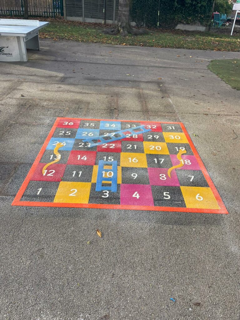 snakes and ladders playground markings, table tennis table behind.