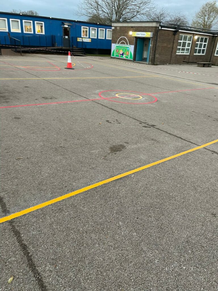 sports court playground markings, buildings behind.